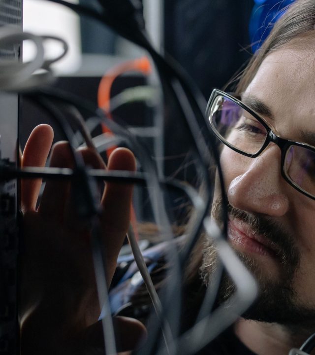 Professional IT specialist handling network cables in a server room.